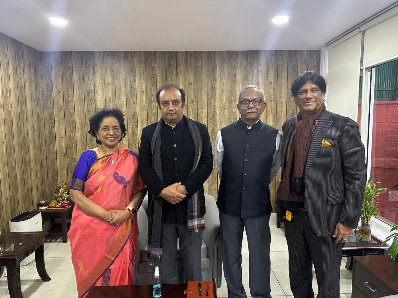 Prem Kumar Singhee standing with three guests at an office meeting